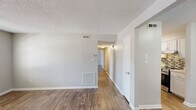 Located at 2130 Westmead Dr SW in Decatur, Alabama, this single-floor, 2-bedroom, 2-bathroom home offers a practical and well-designed layout. Throughout the home, wood-look flooring provides a warm, cohesive aesthetic, complemented by neutral gray walls and textured ceilings.

The living room serves as a welcoming entry point, featuring a front door flanked by windows that allow natural light to fill the space. The galley-style kitchen is a standout feature, equipped with white shaker cabinetry, granite-look countertops, a mosaic tile backsplash, and stainless steel appliances including a range and dishwasher. A dedicated closet adjacent to the kitchen provides additional storage and houses a washer/dryer connection.

The spacious primary bedroom offers a comfortable footprint and includes its own walk-in closet with built-in shelving. The second bedroom also benefits from a window that brings in natural light. Both rooms share the same consistent flooring and neutral tones found throughout the home. The two bathrooms each include a full tub/shower combination with clean white surrounds and chrome fixtures.

A hallway connects the bedrooms to the rest of the home, and multiple interior doors provide clear separation between living areas, offering both privacy and functional organization throughout the space.