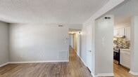 Located at 2130 Westmead Dr SW in Decatur, Alabama, this single-floor, 2-bedroom, 2-bathroom home offers a practical and well-designed layout. Throughout the home, wood-look flooring provides a warm, cohesive aesthetic, complemented by neutral gray walls and textured ceilings.

The living room serves as a welcoming entry point, featuring a front door flanked by windows that allow natural light to fill the space. The galley-style kitchen is a standout feature, equipped with white shaker cabinetry, granite-look countertops, a mosaic tile backsplash, and stainless steel appliances including a range and dishwasher. A dedicated closet adjacent to the kitchen provides additional storage and houses a washer/dryer connection.

The spacious primary bedroom offers a comfortable footprint and includes its own walk-in closet with built-in shelving. The second bedroom also benefits from a window that brings in natural light. Both rooms share the same consistent flooring and neutral tones found throughout the home. The two bathrooms each include a full tub/shower combination with clean white surrounds and chrome fixtures.

A hallway connects the bedrooms to the rest of the home, and multiple interior doors provide clear separation between living areas, offering both privacy and functional organization throughout the space.