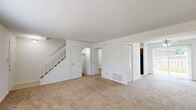 Located at 42 N Lawndale Ave in Indianapolis, Indiana, this two-story home offers three bedrooms, two full bathrooms, and a practical layout spread across two floors. The main level features a carpeted living room filled with natural light from a large front-facing window, with a staircase leading to the upper level. The kitchen is equipped with wood cabinetry, a double-basin sink, tile flooring, and black appliances including a refrigerator and dishwasher, with a window providing additional natural light. A dedicated laundry area with tile flooring, utility hookups, and built-in shelving adds everyday convenience. The upper floor hosts all three bedrooms, each finished with plush carpet and windows that bring in natural light. The spacious primary bedroom offers a comfortable retreat with its own closet. Two additional bedrooms provide flexible space for various needs, each with closet access. The two full bathrooms feature tile flooring, wood vanities, and tub-shower combinations with tiled surrounds accented by a decorative mosaic border. Hallways on both floors connect the spaces efficiently, and multiple closets throughout ensure ample storage. The home's clean, neutral palette creates a bright and move-in ready environment.