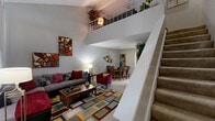 This 880 square foot townhouse in Houston, TX, offers a well-designed living space across two floors. The ground floor, spanning 530 sq ft, features an open-concept living area with tile flooring and high ceilings. A colorful area rug adds warmth to the space, complemented by a comfortable sectional sofa and modern entertainment center. The dining area seamlessly connects to the living room, creating a fluid space for entertaining.

The kitchen, though compact, is efficiently designed with white cabinetry, electric appliances, and ample counter space. A built-in shelf with decorative elements adds character to the cooking area.

Upstairs, the 360 sq ft space accommodates two bedrooms and two bathrooms. The primary bedroom, measuring 150 sq ft, features carpeted flooring, a ceiling fan, and large windows that allow natural light to flood the space. The second bedroom is equally well-appointed with similar amenities.

Both bathrooms are designed with functionality in mind, featuring white tiles, bathtub-shower combinations, and modern fixtures. Pops of yellow in the accessories add a cheerful touch to these spaces.

Throughout the home, neutral wall colors create a blank canvas for personal styling, while ceiling fans in main rooms ensure comfort. The property's layout maximizes space efficiency, making it an ideal option for those seeking a low-maintenance yet comfortable living arrangement in Houston's bustling urban environment.