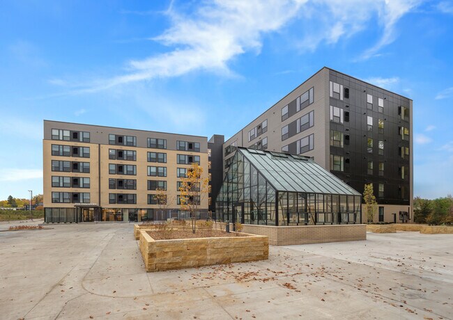 Exterior w/ Greenhouse - The Theodore Apartments 55+