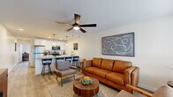 Located at 6806 E County Line Rd in Indianapolis, IN, this thoughtfully designed one-bedroom, one-bathroom unit offers a well-organized single-floor layout that maximizes every square foot. The open-concept living and kitchen area forms the heart of the home, where light wood-look flooring, neutral walls, and a modern ceiling fan create a bright, welcoming atmosphere. Large windows along the living area allow ample natural light to fill the space, complementing the warm-toned leather seating and stylish décor.

The kitchen is a standout feature, boasting white shaker cabinetry, granite countertops, stainless steel appliances, and a peninsula with bar seating — illuminated by sleek pendant lighting. The seamless flow between the kitchen and living room enhances the open feel of the shared space.

The bedroom offers a peaceful retreat with a ceiling fan, a generous sliding-door closet, and a large window overlooking a private outdoor green area. Light wood flooring continues throughout, maintaining a cohesive aesthetic.

The bathroom is both functional and stylish, featuring granite countertops, white cabinetry, and a shower-tub combination. A notable convenience is the stacked in-unit washer and dryer, tucked neatly within the bathroom. Clean lines and neutral tones tie the entire unit together into a cohesive, modern living space.