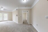 Located at 344 Murray Farm Dr in Fairview, TX, this single-floor, 2-bedroom, 2-bathroom residence offers a well-organized and comfortable layout. The open-concept living and dining area is finished with plush wall-to-wall carpeting, crown molding, and a ceiling fan, creating a warm and inviting atmosphere. Natural light filters in through windows fitted with blinds, adding brightness to the neutral beige tones throughout.

The kitchen is a standout feature, boasting rich dark cabinetry, granite-style countertops, a tile backsplash, and black appliances. Pendant lighting illuminates the breakfast bar peninsula, which connects seamlessly to the living area and makes for an ideal social space.

The primary bedroom is generously proportioned, finished with carpet and crown molding, and provides access to a spacious walk-in closet outfitted with wire shelving on multiple levels. The second bedroom is equally well-sized with its own closet access. Both bathrooms are well-appointed; one features wood-look vinyl flooring, a dark vanity with granite countertops, and a tiled soaking tub with shower combination.

Additional highlights include five closets for ample storage, a dedicated laundry area, a utility room, and a connecting hallway that keeps the layout efficient and functional.