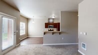 Located at 3517 Hill St SE in Albany, Oregon, this one-bedroom, one-bathroom residence offers a thoughtfully designed single-floor layout that maximizes functionality and comfort. The open-concept living and kitchen area serves as the heart of the home, where warm hardwood-style flooring flows throughout the kitchen and transitions to plush carpet in the living space. The kitchen is equipped with rich dark-toned cabinetry, stainless steel appliances including a refrigerator, range, microwave, and dishwasher, and a light-colored countertop breakfast bar that provides additional seating and workspace. A pendant light fixture adds a modern touch above the bar area. The living room is bright and welcoming, featuring large windows fitted with blinds that invite natural light, along with a glass patio door that opens to an outdoor view — ideal for everyday convenience and ventilation. The bedroom is a comfortable, carpeted retreat with a window overlooking greenery, offering a quiet and private atmosphere. The bathroom includes a full tub-shower combination with clean white surround panels, tile flooring, and brushed nickel fixtures and hardware. Neutral, warm-toned walls throughout the residence create a cohesive and move-in-ready aesthetic.