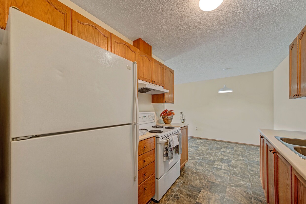 A kitchen with white appliances and light cabinetry - Sol Terrace