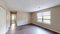 This single-story, 3-bedroom, 1-bathroom home offers a practical and efficient layout across its entire floor plan. Throughout the main living areas, dark hardwood-style flooring provides a durable and cohesive foundation, while textured ceilings and neutral beige walls create a clean, understated aesthetic.

The spacious primary bedroom is a standout feature, offering generous room to accommodate a full furniture arrangement. A large window invites natural light and provides outdoor views, enhancing the sense of openness. The additional two bedrooms feature plush carpeting, individual windows for natural light, and access to closet storage — one notably equipped with a walk-in closet.

The kitchen is efficiently designed with ample light wood cabinetry, dark granite-style countertops, a double sink, and a full suite of black appliances including a range, microwave, dishwasher, and refrigerator. Hardwood-style flooring continues throughout this space.

The full bathroom includes a single-sink vanity with dark countertop and under-sink storage, a toilet, and a full shower-tub combination. A connecting hallway links the bedrooms, bathroom, and main living areas, contributing to a smooth and functional flow throughout the home.