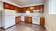 Located at 4665 Kipling St in Wheat Ridge, Colorado, this four-bedroom, one-bathroom single-floor unit offers a functional and well-organized layout. The space is efficiently arranged, with four carpeted bedrooms, a central hallway, a full kitchen, and one shared bathroom. The bedrooms feature neutral-toned walls, plush beige carpeting, and baseboard heating units beneath windows fitted with vertical blinds, allowing natural light to filter in. The generously sized primary bedroom offers ample space for furnishings and includes a closet. Additional bedrooms are similarly appointed, with one featuring hardwood-style flooring, providing versatility for use as a bedroom or flex space. The kitchen is well-equipped with warm wood cabinetry, granite-style countertops, hardwood-style flooring, and white appliances including a refrigerator, electric range, dishwasher, and range hood. The bathroom is clean and bright, featuring white subway tile surrounding a tub-shower combination and a white vanity with chrome fixtures. A connecting hallway ties the rooms together cohesively. Throughout the unit, the consistent neutral color palette and practical finishes create a clean, move-in ready environment suited for everyday living.