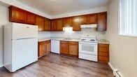 Located at 4665 Kipling St in Wheat Ridge, Colorado, this four-bedroom, one-bathroom single-floor unit offers a functional and well-organized layout. The space is efficiently arranged, with four carpeted bedrooms, a central hallway, a full kitchen, and one shared bathroom. The bedrooms feature neutral-toned walls, plush beige carpeting, and baseboard heating units beneath windows fitted with vertical blinds, allowing natural light to filter in. The generously sized primary bedroom offers ample space for furnishings and includes a closet. Additional bedrooms are similarly appointed, with one featuring hardwood-style flooring, providing versatility for use as a bedroom or flex space. The kitchen is well-equipped with warm wood cabinetry, granite-style countertops, hardwood-style flooring, and white appliances including a refrigerator, electric range, dishwasher, and range hood. The bathroom is clean and bright, featuring white subway tile surrounding a tub-shower combination and a white vanity with chrome fixtures. A connecting hallway ties the rooms together cohesively. Throughout the unit, the consistent neutral color palette and practical finishes create a clean, move-in ready environment suited for everyday living.