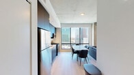 Located at 625 North 2nd Avenue in the heart of downtown Phoenix, this modern one-bedroom, one-bathroom unit showcases a sleek, contemporary design throughout. The open-concept living, dining, and kitchen area is anchored by expansive floor-to-ceiling windows that flood the space with natural light and frame striking views of the Phoenix skyline. Exposed concrete ceilings add an industrial character that contrasts beautifully with crisp white walls and light hardwood flooring found throughout.

The kitchen is thoughtfully designed with dark, flat-front cabinetry extending to the ceiling, white quartz countertops, a subway tile backsplash, and a full suite of stainless steel appliances including a gas range, dishwasher, and refrigerator. The living area offers a comfortable, well-proportioned layout with a dedicated dining space.

The bedroom is a bright, tranquil retreat featuring a tall window with city views, exposed concrete ceiling, and access to a well-organized walk-in closet with built-in shelving. The bathroom is finished with large-format tile, a glass-enclosed walk-in shower with a rain showerhead, a floating wood-tone vanity, white countertop, and an illuminated LED mirror. The unit also includes a dedicated laundry area and entrance, completing this efficient and well-appointed urban residence.
