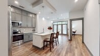 This 680 square foot apartment offers a thoughtful blend of modern design and efficient living. The single-floor layout comprises one bedroom, one bathroom, and an open-concept kitchen and living area. The primary bedroom, measuring 160 square feet, provides ample space for rest and relaxation.

The apartment's contemporary aesthetic is evident in its sleek finishes and architectural elements. Large windows, as seen in the image, flood the space with natural light and offer views of the surrounding area. The wood-look flooring throughout adds warmth and durability to the interior.

The open floor plan maximizes the use of space, creating a sense of flow between the living areas. A hallway and closet provide additional storage solutions, essential for compact urban living. The kitchen, while not visible in the provided image, likely integrates seamlessly with the living area, following the modern design ethos of the space.

This apartment is well-suited for individuals or couples seeking a low-maintenance, high-style urban dwelling. Its efficient use of space and contemporary design make it an attractive option for those prioritizing location and modern amenities in their living arrangements.