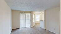 Located at 100 Hunt Club Dr in Copley, Ohio, this one-bedroom, one-bathroom residence offers a well-organized, single-floor layout with a practical and comfortable design throughout. The living area features soft carpeting, a textured ceiling, and a large sliding glass door dressed with vertical blinds that fills the space with natural light. A ceiling fan overhead adds to the room's functionality and comfort. The kitchen flows openly from the dining area and is equipped with stainless steel appliances, including a range, microwave, and refrigerator. White cabinetry pairs cleanly with granite countertops, which extend to a peninsula with a double undermount sink — ideal for casual dining or meal prep. The bedroom is a well-proportioned retreat with plush carpeting, a window overlooking the surrounding neighborhood, and a ceiling fan with light fixture. It connects directly to a spacious walk-in closet outfitted with multiple hanging rods and built-in shelving for ample storage. The bathroom is neatly appointed with a white vanity featuring granite countertops, a large mirror with overhead lighting, and a full soaking tub with shower combination. Wood-look flooring in the bathroom provides a clean, modern contrast. A hallway connects the rooms efficiently, completing this thoughtfully laid-out residence.