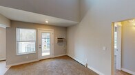 Located at 1252 Hillburn Ave NW in Grand Rapids, Michigan, this two-story home offers a thoughtfully designed layout with clean, modern finishes across both floors. The main level features a well-appointed kitchen equipped with dark espresso cabinetry, light quartz countertops, a double sink, and white appliances including an electric range, microwave, and refrigerator. A dedicated in-unit laundry closet is conveniently situated just off the kitchen, adding everyday practicality. The main level also includes a bright living area with soaring vaulted ceilings, carpeted flooring, a wall-mounted air conditioning unit, and a glass-panel door that opens to an outdoor space, inviting natural light indoors. A striking open staircase with a classic newel post leads to the upper level, where a carpeted hallway with an open railing overlooks the lower floor. The upper level offers a spacious bedroom with three windows providing abundant natural light and neighborhood views, along with a closeted room for additional storage. A full bathroom on this level features a tub-shower combination, tile flooring, recessed lighting, and rich dark wood cabinetry. Throughout the home, neutral tones, recessed lighting, and clean lines create a bright, welcoming atmosphere.