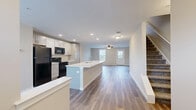 Located at 100 Union Knoll Dr in Middletown, PA, this three-floor home offers 3 bedrooms and 3 bathrooms across a well-organized layout. The entry level features a generously sized utility/garage space with concrete flooring, drywall-finished walls, and an electrical panel — ideal for storage or parking. The main living floor showcases an open-concept kitchen and living area, anchored by a large center island with a white countertop and undermount sink. Gray shaker-style cabinetry, black appliances, and recessed lighting lend a modern, functional aesthetic. Wood-look plank flooring flows throughout this level, complemented by ample natural light from large windows. The upper floors host all three bedrooms, each carpeted for comfort and equipped with ceiling fans. The spacious primary bedroom includes a dedicated bathroom, while additional bedrooms are served by well-appointed full bathrooms featuring gray vanity cabinetry, white countertops, wood-look tile flooring, and tub/shower combinations. Throughout the home, a neutral color palette of warm beige and crisp white tones creates a clean, cohesive atmosphere. The multi-floor layout offers clear separation between living, sleeping, and utility spaces, making this a highly functional and comfortable residence.