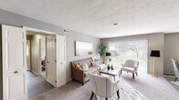 Located in Mayfield, Ohio, this well-appointed single-floor residence offers 2 bedrooms, 1 bathroom, and a thoughtfully designed layout across an expansive footprint. The space features two living areas, with the main living room highlighted by large sliding glass doors that invite abundant natural light and provide views of the surrounding greenery. Neutral-toned carpet, textured ceilings, and warm gray walls create a cohesive, comfortable atmosphere throughout.

The galley-style kitchen is outfitted with white cabinetry, granite-look countertops, black appliances including a refrigerator, range, and microwave, as well as wood-look flooring that extends into the adjacent dining area. The dining room accommodates a ceiling fan, a window with blinds, and a relaxed, intimate atmosphere ideal for everyday meals.

The spacious primary bedroom features plush carpeting and direct access to the full bathroom, which includes a tub-shower combination with a frosted glass sliding door, wood-look tile flooring, and white cabinetry. The second bedroom is equally well-sized with soft carpeting and neutral walls. A hallway and closet complete the functional layout. The outdoor views of mature trees and landscaped grounds add a serene, natural backdrop to this comfortable Mayfield residence.