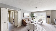 Located in Mayfield, Ohio, this well-appointed single-floor residence offers 2 bedrooms, 1 bathroom, and a thoughtfully designed layout across an expansive footprint. The space features two living areas, with the main living room highlighted by large sliding glass doors that invite abundant natural light and provide views of the surrounding greenery. Neutral-toned carpet, textured ceilings, and warm gray walls create a cohesive, comfortable atmosphere throughout.

The galley-style kitchen is outfitted with white cabinetry, granite-look countertops, black appliances including a refrigerator, range, and microwave, as well as wood-look flooring that extends into the adjacent dining area. The dining room accommodates a ceiling fan, a window with blinds, and a relaxed, intimate atmosphere ideal for everyday meals.

The spacious primary bedroom features plush carpeting and direct access to the full bathroom, which includes a tub-shower combination with a frosted glass sliding door, wood-look tile flooring, and white cabinetry. The second bedroom is equally well-sized with soft carpeting and neutral walls. A hallway and closet complete the functional layout. The outdoor views of mature trees and landscaped grounds add a serene, natural backdrop to this comfortable Mayfield residence.