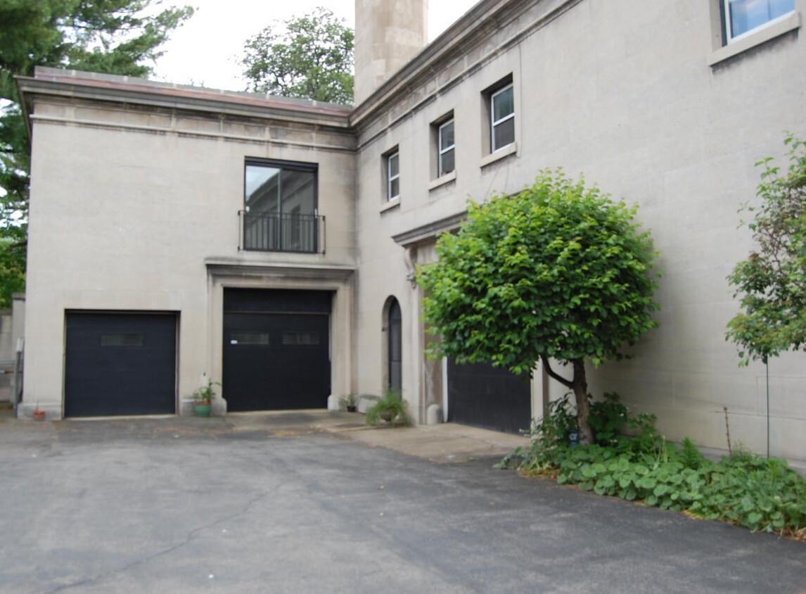 Exterior view of limestone carriage house with new roof and indoor heated parking. - 60 Oakland Pl