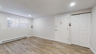 Located at 96 Lawton St in Springfield, Massachusetts, this single-floor unit offers a thoughtfully updated interior with a cohesive, modern aesthetic. Wood-look tile flooring runs throughout the entire space, lending warmth and visual continuity from room to room. The open living area is bright and airy, illuminated by recessed lighting and natural light filtering through slatted blinds, while baseboard heating ensures year-round comfort.

The kitchen is a standout feature, showcasing crisp white shaker-style cabinetry, stainless steel appliances including a refrigerator and electric range, a built-in range hood, and a mosaic tile backsplash with a subtle blend of earth tones and cool accents. A compact layout maximizes efficiency without sacrificing style.

The living spaces flow openly into one another, with clean white walls and generous room proportions creating a versatile, move-in-ready environment. Each room benefits from natural light courtesy of windows fitted with blinds, and the consistent flooring and neutral palette maintain a unified feel throughout.

The bathroom is finished with large-format wall tiles, a decorative mosaic accent border, and a full tub-shower combination enclosed by a sleek sliding glass door with brushed nickel hardware — a polished, functional design. Overall, the space presents a clean, updated, and welcoming interior.