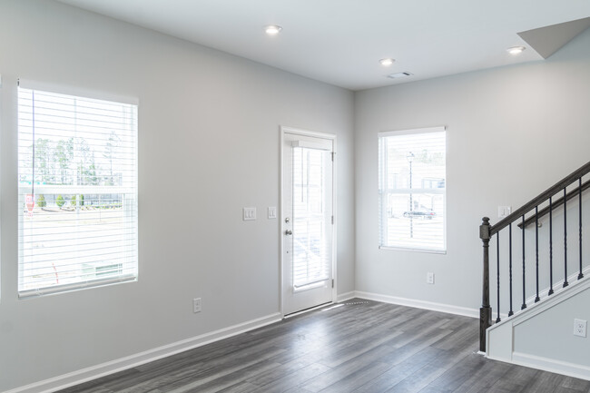 Main entrance opens to a spacious recreation room with a half bathroom. - 2670 Whistler Way NE