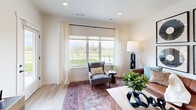 Located at 5400 Fowler Lane in Bozeman, Montana, this thoughtfully designed single-floor residence offers a comfortable and modern living experience. The open-concept kitchen and living area serves as the heart of the home, featuring a large island with a white quartz countertop, dual-tone cabinetry combining white upper cabinets with warm wood lower cabinets, stainless steel appliances including a range, microwave, and refrigerator, and pendant lighting that adds a contemporary touch. The living room is bright and welcoming, with large windows framing views of the surrounding green landscape and allowing abundant natural light to fill the space. Light hardwood-style flooring flows throughout the main living areas, adding warmth and cohesion. The bedroom is a comfortable retreat, finished with plush carpet, a generous window with outdoor views, and access to a dedicated walk-in closet equipped with built-in shelving and hanging rods. The bathroom features a sleek glass-enclosed walk-in shower with a rain showerhead and matte black fixtures, consistent with the home's modern aesthetic. A hallway connects the rooms efficiently, completing this well-organized and stylish layout ideal for single-occupancy or couple living in the heart of Montana.