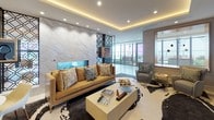This elegantly designed single-floor residence showcases a seamless blend of contemporary architecture and refined interior design. The open-concept living areas are anchored by a dramatic marble feature wall with a built-in fireplace and an ornate geometric metal screen that serves as a striking room divider. Recessed cove lighting and statement pendant chandeliers with metallic rod detailing cast a warm, layered ambiance throughout.

The main living space is generously proportioned, furnished with plush seating in neutral tones accented by gold and mustard yellow cushions, centered on a cowhide rug. Floor-to-ceiling glass walls and sliding doors flood the interior with natural light and open directly onto a spacious outdoor terrace, offering sweeping city skyline views.

A secondary lounge area provides additional seating and a mounted flat-screen television, while a decorative display niche adds a curated touch to the entryway corridor, which features light-toned large-format tile flooring throughout.

The chef's kitchen is outfitted with sleek matte charcoal cabinetry, warm wood accents, white stone countertops, a large central island, stainless steel professional-grade appliances, and a modern pendant light fixture — delivering both style and full culinary functionality in one refined space.