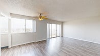 Located at 373 NW 5th St in downtown Oklahoma City, this efficiently designed unit offers a thoughtful layout across a single floor. The combined dining room, kitchen, and living room forms the heart of the space, featuring light-toned luxury vinyl plank flooring, neutral wall tones, and a textured ceiling with a ceiling fan that enhances air circulation. Large windows and a set of sliding glass doors flood the open-concept area with natural light while providing direct access to a private patio that overlooks the Oklahoma City skyline — a standout feature offering elevated urban views. The kitchen is outfitted with white cabinetry and includes a pantry for additional storage. The space includes two full bathrooms, each finished with classic white tile surrounds, mosaic tile flooring, a tub-shower combination, and a vanity with storage. Two closets provide practical storage solutions throughout. A hallway connects the various rooms, contributing to an organized and functional flow. The clean, minimalist aesthetic throughout creates a bright and airy ambiance, making the most of every square foot in this centrally located urban unit.
