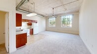 Located at 614 Lynn St in Danville, Virginia, this two-story, three-bedroom, two-bathroom home offers a distinctive blend of industrial character and residential comfort. The layout spans two floors, with the lower level providing a generous living footprint and the upper floor housing the majority of the living space, including a spacious primary bedroom with its own closet.

Throughout the home, soaring ceilings create an open, airy atmosphere, and ceiling fans are present in each bedroom to enhance comfort. The bedrooms are carpeted in neutral tones and benefit from abundant natural light streaming through large, multi-pane industrial-style windows — a standout architectural feature that lends the home a loft-like character. Exposed ductwork and visible structural elements further reinforce this aesthetic.

The two full bathrooms are finished with tile flooring in warm earth tones and include full tub-shower combinations with clean white surrounds and chrome fixtures. Hallways connect the rooms across both floors, with two staircases facilitating circulation between levels. Two closets provide dedicated storage within the home.

The overall ambiance is bright and open, with the oversized windows offering leafy outdoor views that bring a sense of nature indoors. This home's unique architectural details make it a compelling and characterful residence.