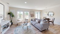 The Cedar is a well-appointed two-story home offering three bedrooms and two and a half bathrooms in Canton, Michigan. The main level features warm hardwood-style flooring throughout the living, dining, and kitchen areas, creating a cohesive and inviting atmosphere. The living room receives abundant natural light through large windows and offers ample space for comfortable seating arrangements. The kitchen is equipped with stainless steel appliances, white shaker cabinetry, a tile backsplash, and a granite-topped peninsula with bar seating — ideal for casual dining and entertaining. A dedicated dining area adjacent to the kitchen provides additional space for meals. A convenient half bathroom and an in-unit laundry room with full-size washer and dryer round out the main floor. Upstairs, the generously sized primary bedroom features plush carpet, a walk-in closet with built-in shelving, a bright window with outdoor views, and a private en-suite bathroom complete with a glass-enclosed shower, granite vanity, and tile flooring. Two additional bedrooms each include closets and carpeted floors, with one offering versatility as a home office. The second full bathroom mirrors the refined finishes found throughout the home, making The Cedar a complete and functional residence.