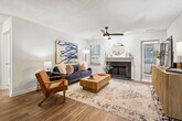 This thoughtfully designed single-floor residence offers 2 bedrooms and 3 bathrooms within a comfortable, functional layout. A welcoming entrance hallway with wood-look flooring leads into the open living and dining areas. The living room is a standout space, featuring a wood-burning fireplace with a decorative mantle, ceiling fan, and windows on two sides that invite natural light throughout the day. The adjacent dining area is accented by a pendant light fixture, chair-rail molding, and a large window with views to the outdoors. The kitchen is efficiently designed with white shaker cabinetry, granite countertops, a subway tile backsplash, stainless steel appliances, and ample storage. Both bedrooms are carpeted and include ceiling fans and closets, with the primary bedroom offering a private en-suite bathroom featuring a granite-topped vanity and wood-look flooring. Additional bathrooms are similarly finished with granite counters, white cabinetry, and tub-shower combinations. The unit also includes a dedicated laundry area, utility room, and three closets, providing generous storage. Textured ceilings are consistent throughout the residence.