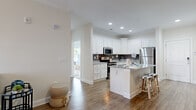 Located on Gunnison Circle in Sumter, SC, this thoughtfully designed single-floor residence offers three bedrooms and a comfortable, open-concept living environment. Warm hardwood-style flooring flows through the main living areas, anchoring a bright and inviting atmosphere enhanced by recessed lighting and crown molding details.

The kitchen is a standout feature, showcasing crisp white cabinetry, granite countertops, a subway tile backsplash, and a full suite of stainless steel appliances. A central island with bar seating connects seamlessly to the dining and living areas, making the space ideal for both everyday living and entertaining. The living room opens to a private balcony through elegant French doors, flooding the space with natural light.

The primary bedroom is generously sized with plush carpeting, a ceiling fan, and a large window offering outdoor views. A spacious walk-in closet with built-in shelving provides ample storage. Additional bedrooms are equally well-lit and comfortable, each with carpeted floors, ceiling fans, and windows overlooking the surrounding greenery. The bathroom features wood-style flooring, granite vanity countertops, and a full tub-shower combination.
