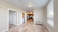 Located at 375 Osprey Ln in Independence, Oregon, this well-designed one-bedroom, one-bathroom unit offers a clean, contemporary aesthetic throughout its efficiently utilized single floor. Light wood-style flooring flows seamlessly across all rooms, creating a cohesive and bright atmosphere.

The kitchen is a standout feature, showcasing rich warm-toned wood cabinetry extending to the upper walls, paired with crisp white countertops and a full suite of stainless steel appliances, including a French door refrigerator, electric range, and dishwasher. Recessed lighting and windows with blinds allow ample natural light into the space, while a direct-access door leads to an outdoor balcony area.

The open living area connects naturally to the kitchen, offering a functional layout with a wall-mounted climate control unit. A dedicated in-unit laundry area provides added convenience. Two closets offer generous storage throughout the unit.

The bedroom features a sliding-door closet and multiple windows that bring in natural light and neighborhood views. The bathroom is appointed with a warm wood vanity, white countertop, large mirror, and a shower-tub combination. Neutral warm-beige tones throughout the unit create a calm, welcoming ambiance suited for comfortable everyday living.