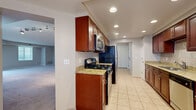 Located at 26600 George Zeiger Dr in Beachwood, OH, this well-appointed 2-bedroom, 2-bathroom single-floor residence offers a thoughtfully designed layout with generous living space. The expansive living and dining area is a standout feature, showcasing plush wall-to-wall carpeting, neutral tones, and large sliding glass doors flanked by multiple windows that flood the space with natural light and provide access to an outdoor area. Track lighting and recessed fixtures ensure the space is well-lit throughout. The galley-style kitchen is efficiently designed with rich dark wood cabinetry, granite countertops, a decorative tile backsplash, and stainless steel appliances including a gas range, built-in microwave, refrigerator, and dishwasher. Light ceramic tile flooring completes the kitchen's clean, functional aesthetic. Both bedrooms are comfortably sized, carpeted, and feature windows with blinds that allow for adjustable natural light. The primary bedroom is particularly spacious, offering ample room for a full furniture suite. Two full bathrooms include classic white tiled tub-shower combinations with chrome fixtures. Additional features include two closets, a hallway connecting the main spaces, and tile flooring in utility areas, rounding out this move-in-ready Beachwood residence.