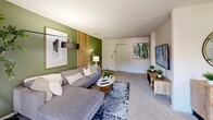 This 2-bedroom, 2-bathroom residence in Wilmington, Delaware offers a thoughtfully designed single-floor layout with a comfortable and modern aesthetic throughout. The open-concept living and dining area forms the heart of the home, where a bold sage green accent wall with vertical wood slat detailing anchors the living room, complemented by soft carpet flooring and natural light streaming through sliding glass doors that lead to a balcony. The dining area features a stylish chandelier, matching green accent wall, and additional sliding door access to outdoor views, creating a bright and inviting atmosphere. The kitchen is equipped with light wood cabinetry, dark countertops, black appliances including a gas range and built-in microwave, and tile flooring, with a window providing natural light. The spacious primary bedroom includes a generous closet with built-in shelving, offering ample storage. The second bedroom is equally well-sized with its own closet access. Two full bathrooms, each with a tub-shower combination, serve the residence. A dedicated entrance, hallway, and closet round out the functional layout, making this a well-organized and move-in ready home in the Wilmington area.