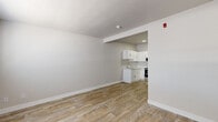 Located at 370 E Harmon Ave in Las Vegas, NV, this efficient single-floor unit offers a well-organized layout comprising a living room, kitchen, bathroom, and closet. The interior is finished with wood-look plank flooring throughout, lending warmth and visual continuity across all spaces.

The living area is bright and open, featuring neutral white walls, clean white baseboards, and a window fitted with blinds that allows natural light to filter in. A wall-mounted HVAC unit provides climate control, and the entry door opens directly into this welcoming main space.

The kitchen is thoughtfully designed with white shaker-style cabinetry, light countertops, and a single-basin sink. It is fully equipped with stainless steel appliances, including a refrigerator, electric range with overhead microwave, making it functional for everyday cooking needs.

The bathroom is clean and well-appointed, featuring a tub-shower combination with tiled surround, a toilet, and a vanity with a light countertop surface and a large mirror. White cabinetry provides additional storage within the space.

A dedicated closet offers practical storage, and an electrical panel is conveniently accessible near the kitchen area. The overall aesthetic is clean, modern, and move-in ready, making this unit a practical option in the heart of Las Vegas.