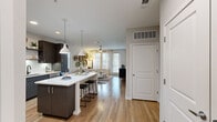 Located at 881 W Warren Ave in Longwood, FL, this thoughtfully designed 2-bedroom, 2-bathroom residence offers a seamless single-floor layout with stylish modern finishes throughout. The open-concept kitchen and living area serves as the heart of the home, featuring dark espresso cabinetry, a white quartz island with bar seating, stainless steel appliances, and pendant lighting — all set atop warm wood-style flooring. The living room extends naturally from the kitchen, bathed in natural light from large windows and a glass door that opens to a private balcony, and is finished with a ceiling fan overhead. Both bedrooms are generously proportioned, carpeted for comfort, and accented by bold feature walls. The spacious primary bedroom receives abundant natural light through large windows and is served by a full en-suite bathroom and a walk-in closet with wire shelving. The second bedroom is equally well-appointed with its own dedicated closet and easy access to the second full bathroom. Both bathrooms feature dark vanity cabinetry with quartz countertops and a shower/tub combination. Throughout the residence, neutral tones and clean architectural lines create a cohesive, contemporary ambiance well suited to everyday living.