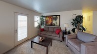 This single-floor residence features two bedrooms and one bathroom within a thoughtfully arranged floor plan. The living room provides a welcoming, comfortable space with carpet flooring, large windows that invite natural light, and room for generous seating arrangements. Adjacent to the living area, a dedicated dining space offers ample room for a full dining table, making it ideal for everyday meals or entertaining.

The galley-style kitchen is well-equipped, featuring wood-toned cabinetry, dark granite-style countertops, and white appliances including a range, microwave, refrigerator, and dishwasher. Durable wood-look flooring runs throughout the kitchen, which also provides direct access to an in-unit washer and dryer area — a highly practical convenience.

Both bedrooms are carpeted and feature neutral walls and natural light from windows with blinds, offering a calm and restful atmosphere. Each room comfortably accommodates a queen-sized bed and additional furniture.

The full bathroom includes a wood-vanity with granite-style countertop, a soaking tub with shower, and wood-look flooring, presenting a clean and functional design. Overall, this residence delivers a practical and comfortable living experience with cohesive finishes throughout.