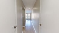 Located at 499 Northside Cir NW in Atlanta, GA, this efficiently designed single-floor unit offers a thoughtful layout that maximizes every square foot. Light wood-look flooring runs throughout the space, complemented by neutral warm-toned walls and crisp white trim, creating a clean and cohesive aesthetic.

The entrance opens into a well-lit hallway with a textured ceiling, leading into the main living area. The living space features vaulted ceilings that lend an open, airy feel, and a glass balcony door flanked by large windows allows abundant natural light to fill the room while providing outdoor access and views.

The kitchen is a standout feature, showcasing white shaker cabinetry, a classic white subway tile backsplash, and a suite of stainless steel appliances including a refrigerator, range, and built-in microwave. A generous stone-topped peninsula with an undermount sink adds prep space and a natural gathering point.

The bathroom is finished with wood-look flooring, a gray vanity with a clean white countertop, and a full tub-shower combination with a curved curtain rod. In-unit laundry adds a practical convenience. The space is rounded out by a dedicated entrance and hallway, ensuring a functional and organized flow throughout.