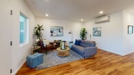 Located at 240 Broadway in Chula Vista, San Diego, this single-floor residence offers a cohesive, modern design with warm hardwood flooring flowing throughout every room. The open layout connects key living areas seamlessly, creating a functional and inviting atmosphere.

The living room is generously proportioned, featuring recessed lighting, a wall-mounted mini-split air conditioning unit, and large windows that allow natural light to fill the space. Clean white walls provide a neutral backdrop that complements the mid-century modern furnishings.

The kitchen is designed for efficiency and style, outfitted with stainless steel appliances including a gas range, microwave, French door refrigerator, and dishwasher. White cabinetry with brushed nickel hardware pairs with light countertops, while a window above the sink brings in additional natural light.

The bedrooms are bright and comfortable, each featuring windows that invite natural light. One bedroom includes a walk-in closet, while another offers a cheerful, light-filled atmosphere suited for a variety of uses.

Two bathrooms serve the unit, each featuring a tub-shower combination, white tile surround, hardwood flooring, and clean white walls. One bathroom includes a well-lit vanity mirror, adding a refined touch to the space overall.