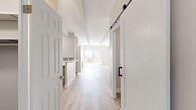 Located at 240 S Monaco St Pkwy in Denver, CO, this well-appointed 2-bedroom, 2-bathroom residence offers a thoughtfully designed single-level layout with modern finishes throughout. Light wood-look flooring flows through the main living areas, complemented by a neutral color palette and exposed beam detailing on textured ceilings that add architectural character.

The open-concept kitchen is a standout feature, showcasing gray cabinetry, white quartz countertops, a mosaic tile backsplash, and a full suite of stainless steel appliances including a refrigerator, range, microwave, and dishwasher. A peninsula provides additional prep space and casual seating. A dedicated pantry with built-in shelving adds practical storage. A stylish sliding barn door accents the entry hallway.

The bright living room opens directly to a private balcony, where sweeping views of the Denver skyline, treetops, and the distant Rocky Mountains create a scenic backdrop. The spacious primary bedroom features plush carpet, dual reach-in closets with built-in shelving, and access to natural light. The second bedroom is equally well-sized with soft carpet and exposed beam details.

Both bathrooms are updated with dual-sink vanities, gray cabinetry, white quartz countertops, and large framed mirrors with modern lighting, offering a clean, contemporary aesthetic throughout.