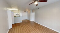 Located at 1702 Skinner St in Freeport, TX, this single-story, one-bedroom, one-bathroom home offers a practical and well-organized layout. The combined kitchen and living area forms the heart of the home, with warm-toned luxury vinyl plank flooring running throughout. A ceiling fan with integrated lighting adds comfort to the living space, while a large window invites natural light and outdoor views, creating a bright and welcoming atmosphere.

The kitchen is efficiently designed with ample white cabinetry accented by wood-toned trim, a granite-style countertop, and a peninsula that provides additional workspace and storage. White appliances, including a range, refrigerator, microwave, and dishwasher, complete the functional setup.

The bedroom is a comfortable retreat featuring plush carpeting, a ceiling fan, and a generously sized window that frames views of the surrounding greenery. A dedicated closet provides practical storage.

The bathroom is thoughtfully equipped with accessibility features, including grab bars near the toilet and shower area. It features a vanity with a sink, a large mirror, and matching vinyl plank flooring. A hallway connects the rooms, contributing to a cohesive and easy-to-navigate floor plan. The overall aesthetic is clean, neutral, and move-in ready.