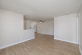 Located in San Diego, CA, this 2-bedroom, 2-bathroom single-floor residence offers a thoughtfully organized layout that maximizes functionality. The living room features light wood-style flooring, a textured ceiling, and a sliding glass door that opens directly onto a private balcony, allowing natural light to fill the space and providing pleasant outdoor views. A ceiling fan adds to the comfort of the living area. The combined dining room and kitchen is bright and efficient, outfitted with white cabinetry, white appliances including a refrigerator and electric range, a built-in sink, and the same wood-style flooring that continues throughout the main living areas. Both bedrooms are carpeted and receive natural light through slatted windows. The primary bedroom includes a mirrored sliding closet, while the second bedroom benefits from its own dedicated closet with built-in shelving and hanging rods. Each bathroom features a full tub-shower combination with clean white surrounds, a vanity, and wood-style flooring. A dedicated laundry area and a connecting hallway complete the floor plan. The overall aesthetic is clean, neutral, and move-in ready.