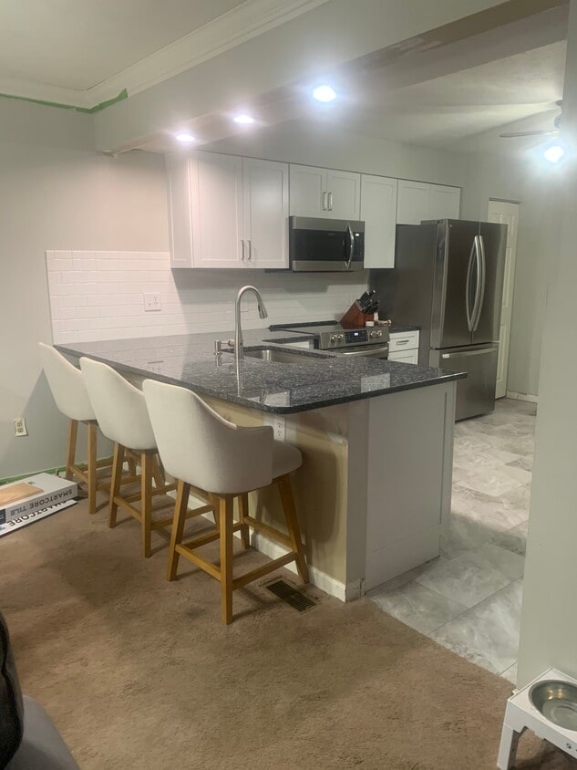 Granite countertops throughout with subway tile backsplash. And, all new higher end appliances. - 704 Carters Grove Dr