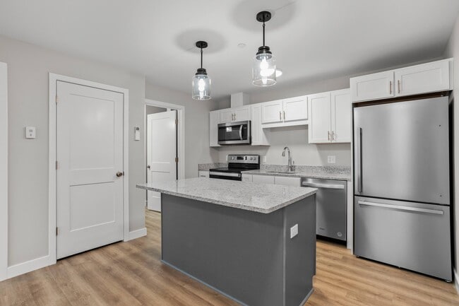 Efficient kitchen with full appliance package, granite island, and ample storage. - The Parker