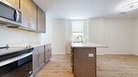 This efficiently designed apartment in Cincinnati, OH, offers 440 square feet of contemporary living space. The property features two bedrooms, including a primary bedroom of 110 square feet, and two bathrooms. The modern kitchen is equipped with stainless steel appliances, wood-tone cabinetry, and a practical island, creating an open-concept living area with light wood-style flooring throughout.

The bathrooms showcase a blend of luxury and functionality, with one featuring a striking black and white patterned tile floor, a glass-enclosed shower, and marble-effect walls. In-unit laundry facilities add convenience to daily living. Large windows in the bedrooms and living areas allow for ample natural light, enhancing the sense of space.

Storage solutions are thoughtfully integrated, with built-in closets in the bedrooms. The apartment's layout maximizes the use of space, creating a comfortable and efficient home environment. The neutral color palette and contemporary fixtures contribute to a clean, modern aesthetic throughout the entire unit.