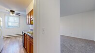 Located at 3528 Aquila Cir in St. Louis Park, MN, this single-floor unit offers three bedrooms, one bathroom, and a practical, well-organized layout. The galley-style kitchen features warm wood cabinetry, granite-look countertops, a double sink, hardwood-style vinyl flooring, and includes a full suite of appliances — refrigerator, range, and dishwasher — along with in-unit washer and dryer. The living area is bright and open, with large windows dressed in vertical blinds that allow ample natural light, complemented by neutral carpet flooring and a wall-mounted air conditioning unit. The primary bedroom is generously sized with two exposures of natural light, a ceiling fan, carpet flooring, and baseboard heating. The additional bedrooms are carpeted and each feature closets with built-in shelving and hanging rods. The bathroom is finished with classic white mosaic tile flooring, full wall tile surround, a vanity with storage, and a window for natural light. A hallway connects all rooms efficiently, and the entrance provides a welcoming transition into the home. Clean, neutral finishes throughout create a move-in ready environment.