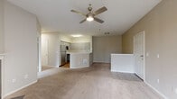 This thoughtfully designed 2-bedroom, 1-bathroom residence in Everett, Washington offers a comfortable and functional single-floor layout. The open-concept living, dining, and kitchen area serves as the heart of the home, anchored by a striking black-tiled fireplace with a white mantel and ceiling fan in the living room. Sliding glass doors lead to a private balcony with views of surrounding greenery, filling the space with natural light. The kitchen is well-equipped with grey shaker-style cabinetry, white countertops, stainless steel appliances including a refrigerator, dishwasher, and range, and warm hardwood-style flooring. A curved peninsula provides additional workspace and a natural divide between the kitchen and living area. A carpeted hallway connects the bedrooms, each featuring ceiling fans and closet storage. The primary bedroom is generously sized with its own closet access. The bathroom includes a full soaking tub and shower combo with hardwood-style flooring. With six closets throughout, storage is plentiful. Neutral tones and warm carpeting unify the space, creating a calm and welcoming atmosphere throughout.