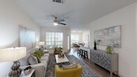 Located in Houston, TX, this single-story residence offers a thoughtfully designed open-concept floor plan with a bright, contemporary aesthetic. The living area is generously proportioned, featuring wood-look flooring, vaulted ceilings with ceiling fans, and large windows dressed with horizontal blinds that invite an abundance of natural light. The space flows seamlessly into a dedicated dining area, where a sizable window frames outdoor greenery, creating an inviting atmosphere for gatherings.

The kitchen is a standout feature, showcasing granite countertops, a large island with bar seating, gray cabinetry with brushed nickel hardware, and stainless steel appliances including a refrigerator and dishwasher. An in-unit laundry area is conveniently accessible from the kitchen corridor.

Two well-appointed bedrooms each feature ceiling fans, wood-look flooring, and large windows that allow ample natural light. The bathroom includes a granite-topped vanity with gray cabinetry and a full tub-shower combination. A built-in study nook with a granite desktop and shelving provides a practical workspace. Throughout, the neutral color palette and consistent flooring create a cohesive, modern ambiance.