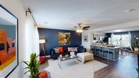 This three-floor home offers a well-organized layout designed for comfortable everyday living. The main living area is an inviting, open space anchored by hardwood-style flooring, a ceiling fan, and a bold navy accent wall that adds depth and character. Natural light filters through windows dressed with sheer curtains, creating a bright and welcoming atmosphere. The living room flows seamlessly into a breakfast bar and dining area, providing a practical transition between spaces.

The kitchen is a functional highlight, featuring slate-blue cabinetry, light countertops, and a full suite of stainless steel appliances, including a range, microwave, and dishwasher. Ample upper and lower cabinet storage makes the kitchen as practical as it is visually appealing.

The bedrooms are generously proportioned, each with ceiling fans, carpeted floors, and their own accent walls. Closets with double doors provide ample storage, and windows allow natural light to brighten each room. The bathrooms are clean and straightforward, each offering a tub-shower combination, tile flooring, and vanity with storage.

Staircases connect all three floors, and the overall layout provides a logical separation between living, sleeping, and utility spaces throughout the home.