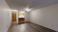 This one-bedroom, two-bathroom unit at 1111 47th St SE in Everett, Washington offers a practical and well-organized single-floor layout. The living room is an open, inviting space highlighted by dark hardwood-style flooring, a ceiling fan, and a sliding glass door that brings in natural light and provides direct access to an outdoor area. A peninsula counter connects the living area to the galley-style kitchen, which features warm honey-toned cabinetry, dark countertops, a full suite of white appliances including a refrigerator, electric range, and dishwasher, and ample upper and lower cabinet storage. Textured ceilings are present throughout the unit. The bedroom offers a comfortable footprint with dark hardwood-style floors, a window allowing natural light, and a sliding-door closet providing dedicated storage. Both bathrooms are clean and functional, with one featuring a full tub-shower combination with tiled surround. A dedicated in-unit laundry area houses a stacked washer and dryer, adding significant convenience. The hallway connects the rooms efficiently, completing the thoughtfully utilized layout of this Everett residence.