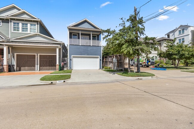 Vista frontal desde la calle 23 Oeste. La casa está orientada al sur. Tanto la entrada para vehículos como el garaje tienen capacidad para dos coches cada uno. - 1221 W 23rd St