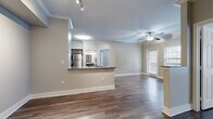 This single-floor residence opens through a tiled entryway equipped with a thermostat and intercom panel, setting a functional tone from the start. The open-concept living and dining area is defined by warm hardwood-style flooring, crown molding, and a ceiling fan with light fixture. Natural light filters through blinded windows, and a pass-through granite countertop connects the living space to the kitchen, enhancing the open feel.

The kitchen is well-appointed with gray cabinetry, granite countertops, a subway tile backsplash, and a full suite of stainless steel appliances including a range, microwave, dishwasher, and refrigerator. Crown molding and wood-look flooring continue throughout.

The bedrooms are generously sized, each featuring hardwood-style flooring, ceiling fans, and windows with exterior views. Six-panel doors and neutral walls maintain a clean, cohesive aesthetic throughout.

The bathrooms are finished with granite-topped vanities, gray cabinetry, wood-look flooring, and tub/shower combinations featuring large-format tile surrounds and brushed nickel fixtures, offering a polished, uniform design.